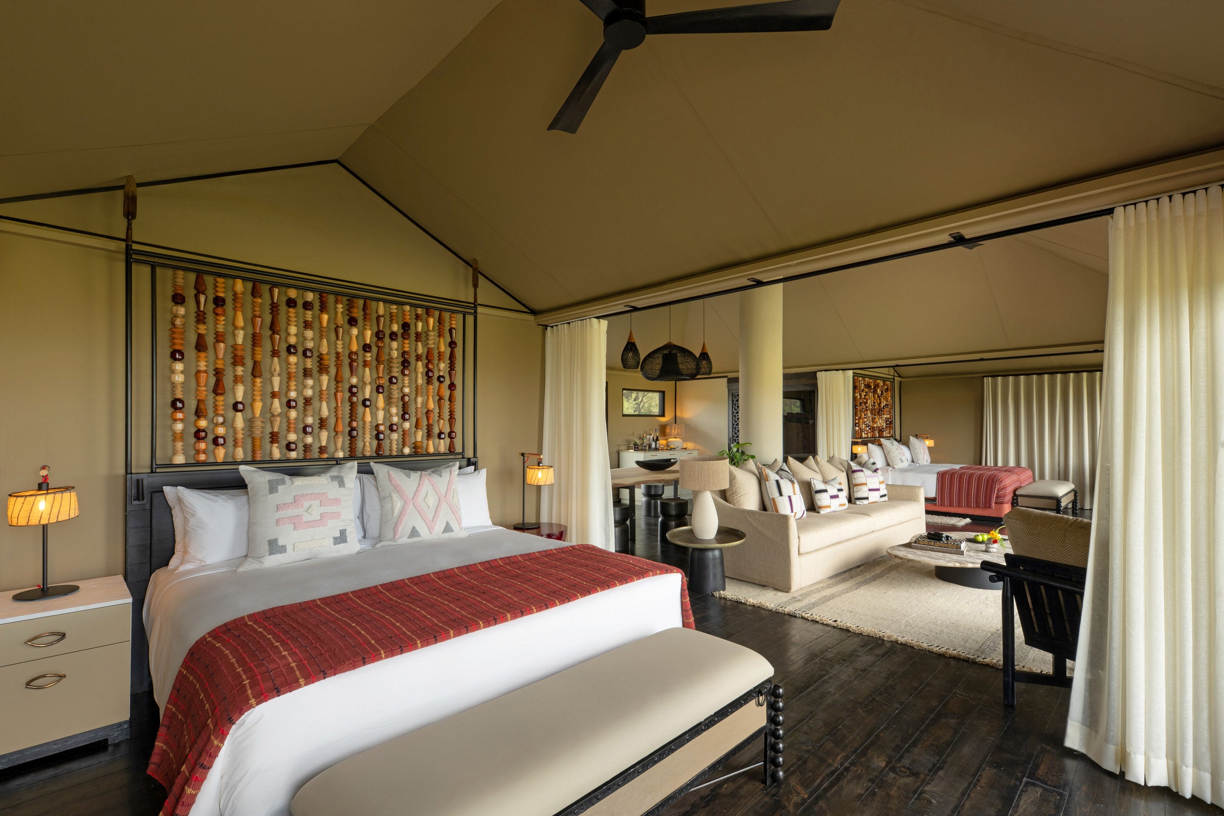 Luxury bedroom with bed, seating area, and decor in a well-lit room.