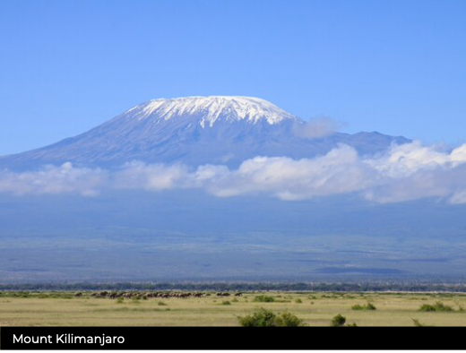Mount Kilimanjaro with snow-capped peak against a blue sky