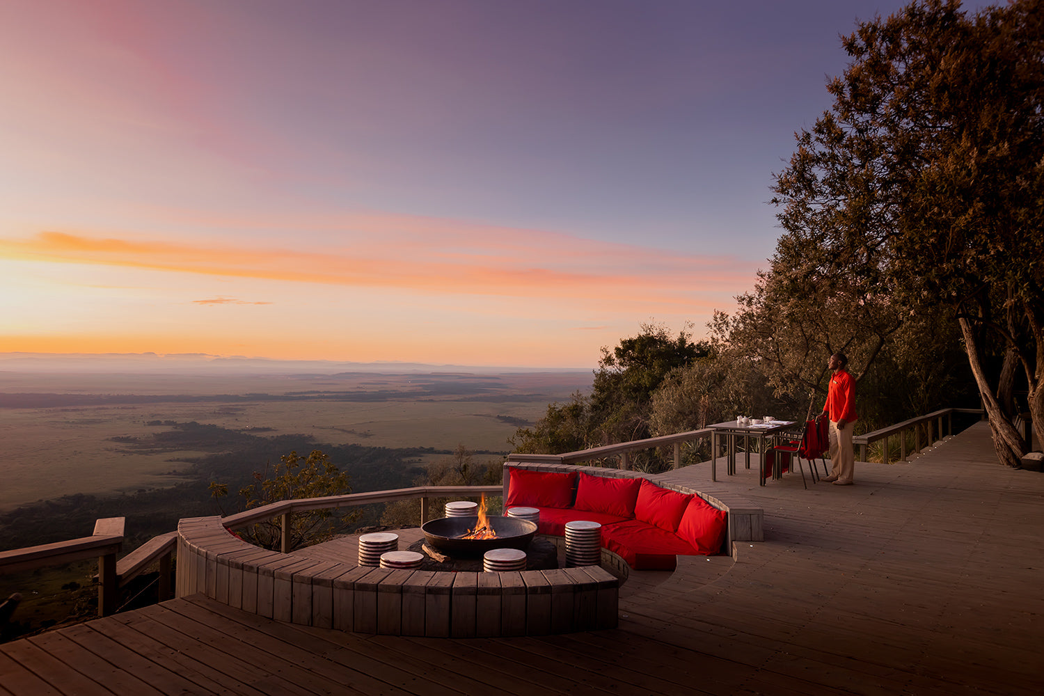 An intimate outdoor evening at Angama Mara, gathered around a glowing fire pit as the sun fades over the Maasai Mara. Warm flames, soft blankets, and panoramic views create a serene moment where comfort meets wilderness, inviting you to savor the beauty of the plains long after daylight slips away.