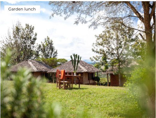 Outdoor setting with wooden huts and a table under a tree, labeled 'Garden lunch'.