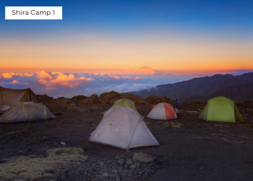 Camping tents set up at Shira Camp 1 with a stunning sunset over the mountains.