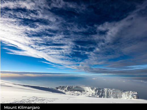 Snowy mountain landscape with a cloudy sky, labeled 'Mount Kilimanjaro'.